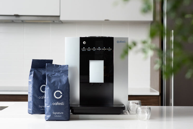 Machine & Coffee Subscription - Cafesti automatic coffee machine and premium coffee beans with glass coffee cups on a kitchen counter