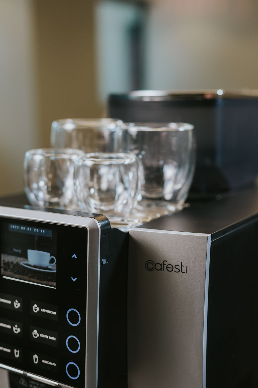 Cafesti Grande automatic coffee machine making a milk-based coffee drink- image showing the frothed milk dispensed into a glass cup